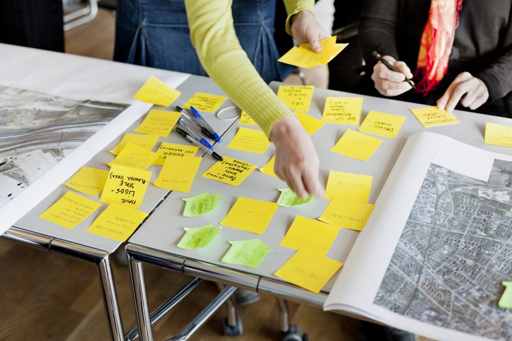 Cropped image of business people strategizing with sticky notes in office